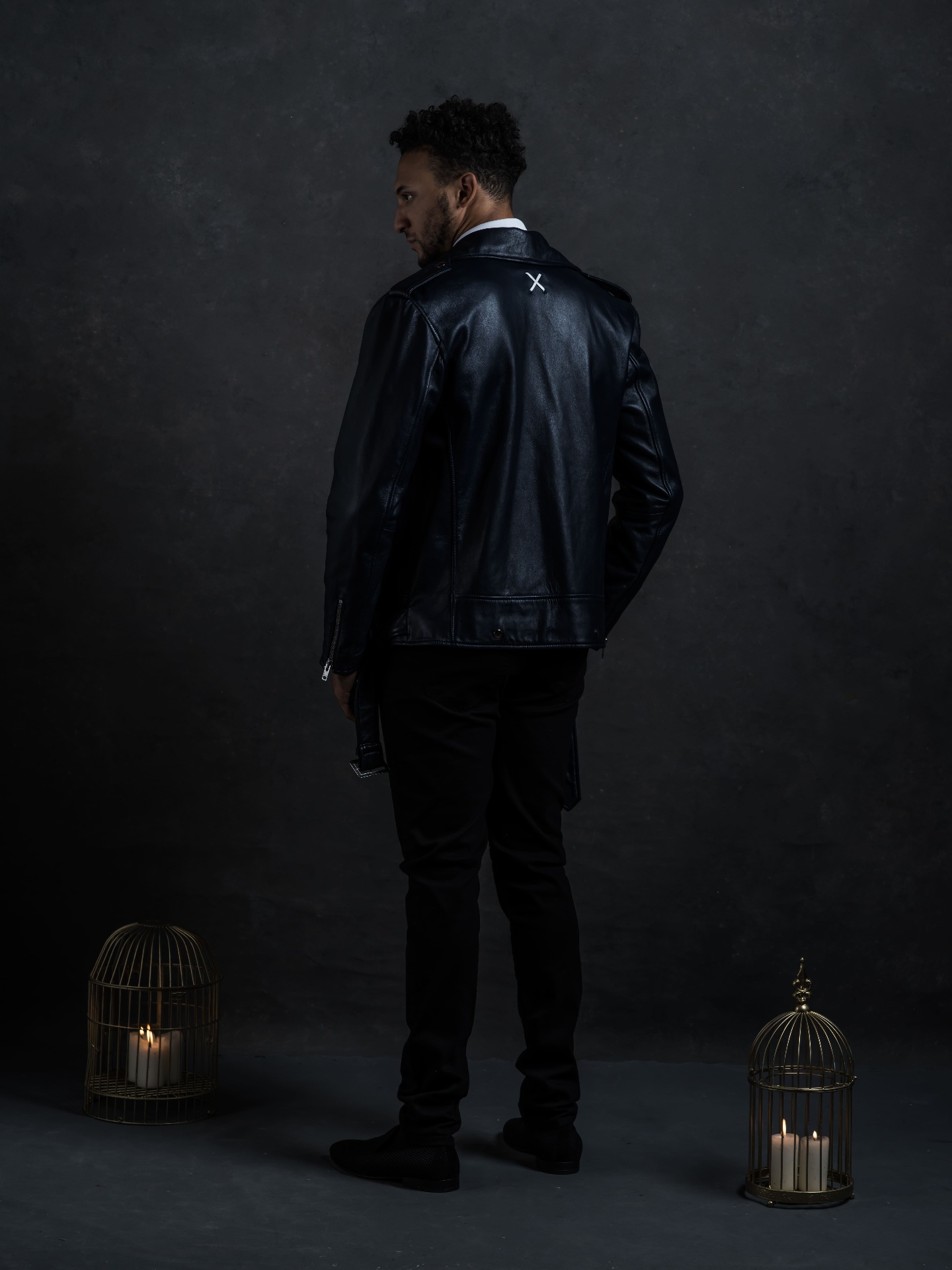 INCARNATE leather jacket photographed from behind, dark studio light